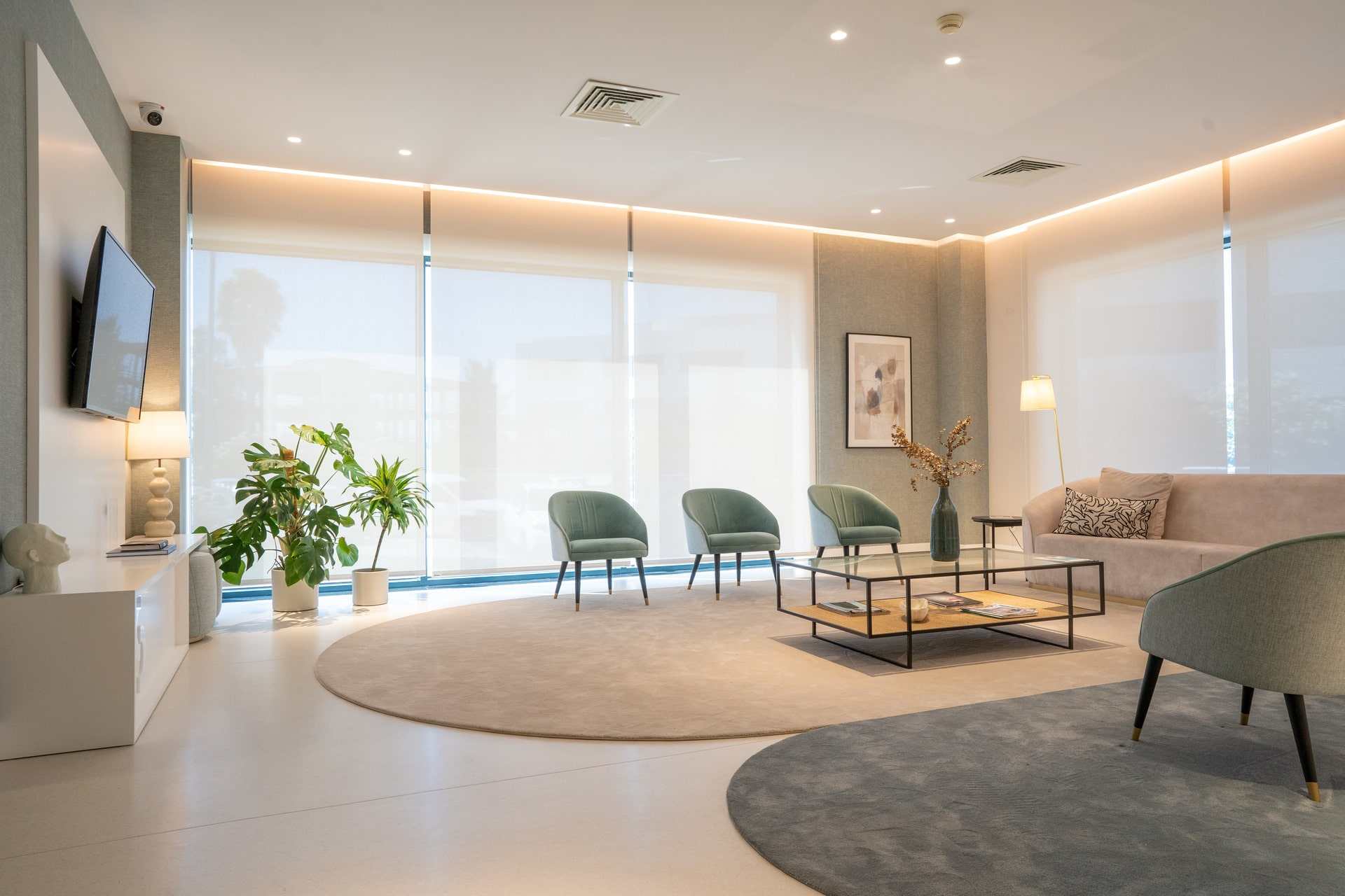 Clínica da Beloura: a spacious waiting room with natural light, armchairs and plants