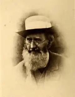 Old sepia portrait of Richard Spruce, an elderly man with a white beard, spectacles and a pale brimmed hat.