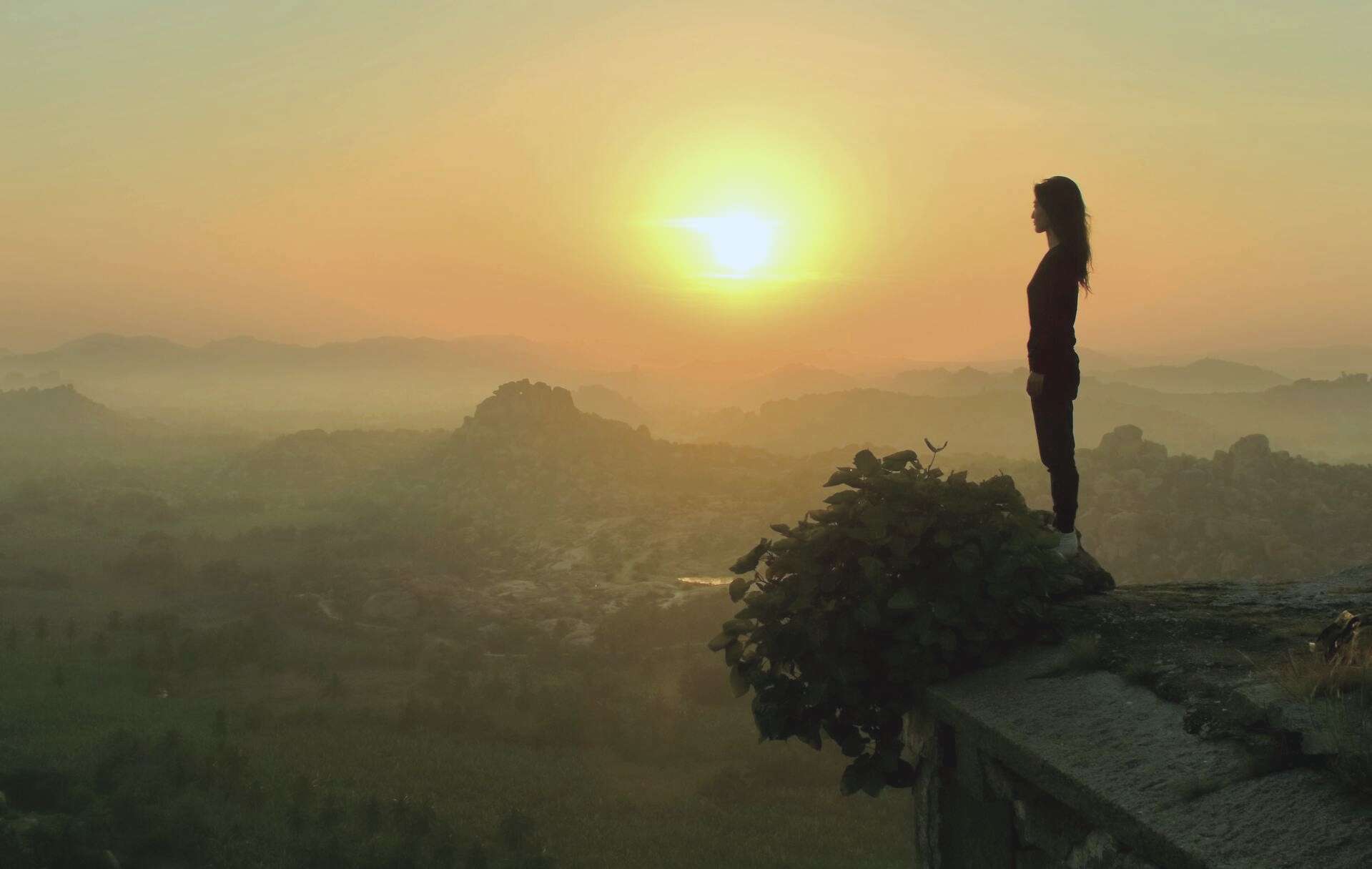 A person at a viewpoint at sunrise