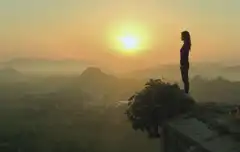 A person at a viewpoint at sunrise